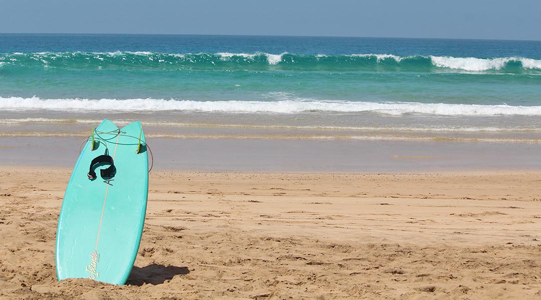 eigenes surfbrett - türkises fish-board am strand