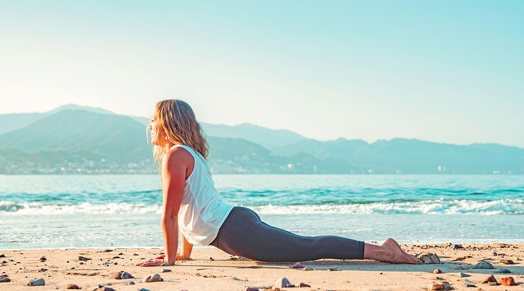 stretchen nach dem surfen - cobra pose am strand