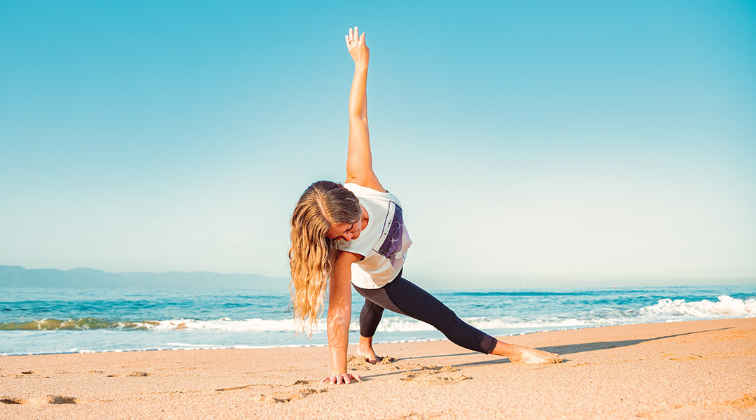 stretchen nach dem surfen - dreiecks pose am strand